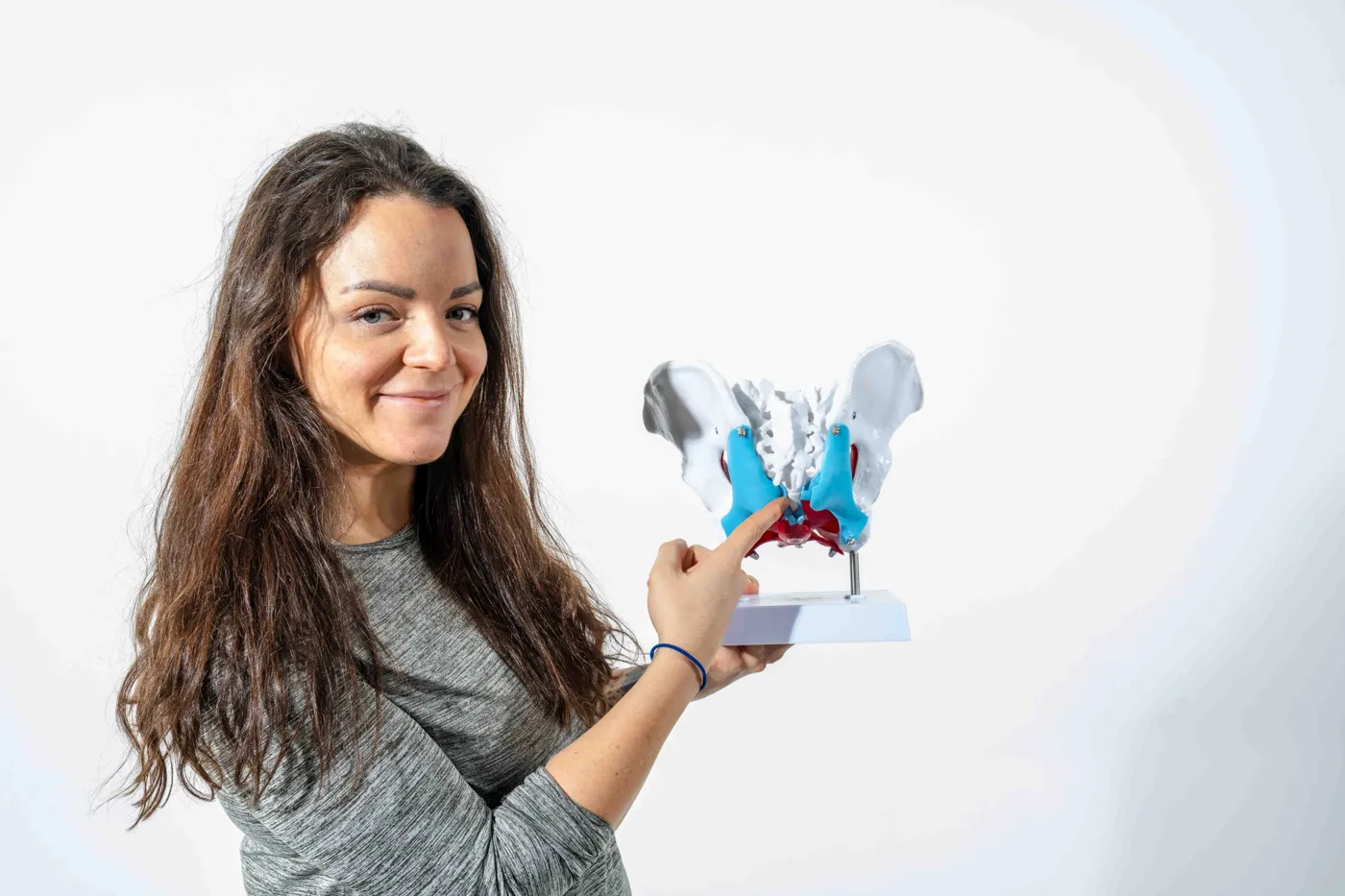 Kiropraktor Sara Nordanger viser halebeinet på en bekkenmodell